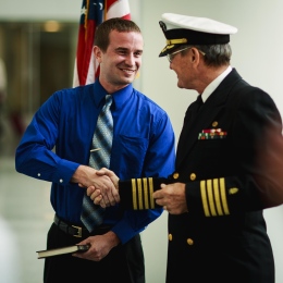 Dr. Richard Harper (right) congratulates OSU alumnus Kyle Shepard for being selected to be commissioned into the US Navy at a ceremony June 24 at Cleveland Clinic.