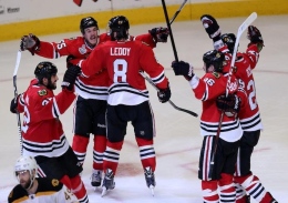 Chicago Blackhawks' Andrew Shaw, second from left, celebrates with teammates after scoring the winning goal in a third overtime against the Boston Bruins in Game 1 of the NHL Finals on June 12 at the United Center in Chicago. 