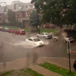 A car drives down Chittenden Avenue Monday in the midst of the Columbus thunderstorms.