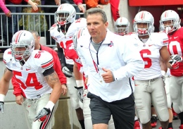 OSU football coach Urban Meyer runs onto the field with players during the 2012 Spring Game. Meyer released a statement disciplining four Buckeyes Monday.