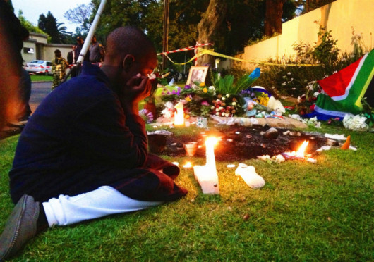 A boy lights a candle outside the house of former South African President Mandela, Dec. 6, 2013 in Johannesburg, South Africa. The South African anti-apartheid hero died peacefully at home at the age of 95 on Thursday, Dec. 5, after months fighting a lung infection.