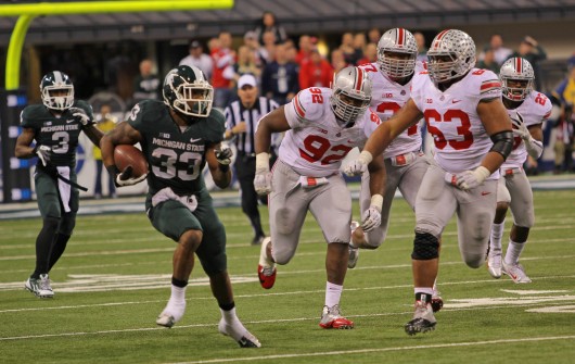 Then-junior defensive lineman Michael Bennett (63) chases a Michigan State player during the Big Ten Championship Game against the Spartans on Dec. 7, 2013, at Lucas Oil Stadium in Indianapolis. OSU lost, 34-24. Credit: Lantern file photo