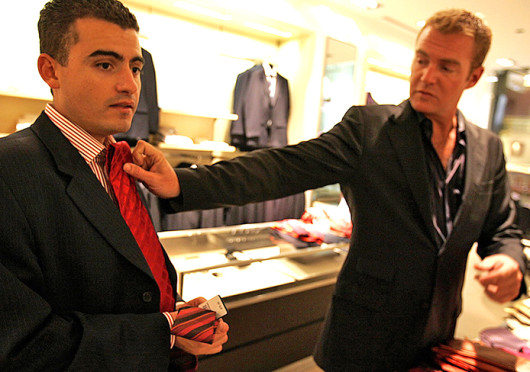 Fernando Beteta (left) tries a tie with the help of sales associate Michael Andersen of the Hugo Boss store in Chicago.