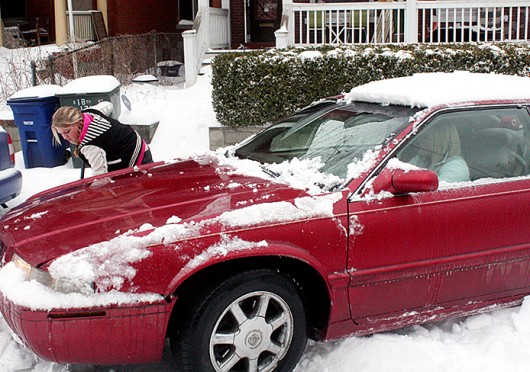 Candi Griffin, Columbus resident, shovels snow from underneath Amanda Cheek, Columbus resident’s, car Feb. 5 at South 18th Street.<br />Credit: Jonathan McAllister / Lantern photographer