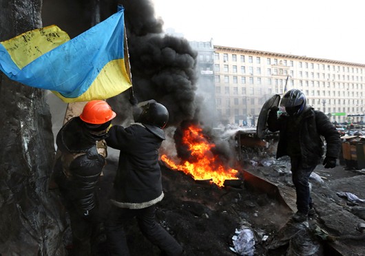 Ukrainian protesters raise a national flag over a barricade on Grushevsky Street in downtown Kiev during clashes with riot police Jan. 25. Credit: Courtesy of MCT