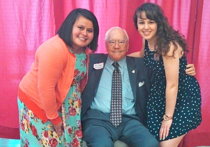Haley de Leon (left) and Michele Theodore (right), members of Mount Leadership Society, pose for a picture with John Mount at an event for the organization April 7.