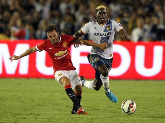 Manchester United's Juan Mata, left, and the Los Angeles Galaxy's Gyasi Zardes fight for the ball in an exhibition game at the Rose Bowl in Pasadena, Calif., on July 23. Manchester won, 7-0.  Credit: Courtesy of MCT