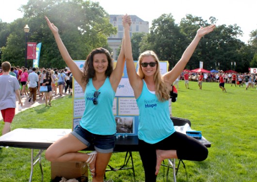 Hannah Rinehardt, a third-year in chemistry and Breathe Hope president, and second-year health promotion, nutrition, and exercise science major and Breathe Hope’s campus Yoga Instructor Hailey Schwertner hold the yoga position “tree pose” at the Ohio State University Student Involvement Fair to gain members for new student organization Breathe Hope on Aug. 24, 2014.  Breathe Hope is the first Ohio State student organization that aims to spread awareness and raise funds for cystic fibrosis research. 