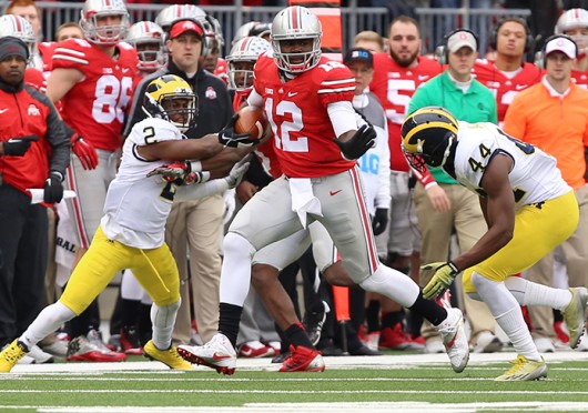 OSU redshirt-sophomore quarterback Cardale Jones (12) carries the ball as Michigan junior defensive back Blake Countess (2) and sophomore safety Delano Hill (44) defend during a Nov. 29 game at Ohio Stadium. OSU won, 42-28. Credit: Lantern file photo