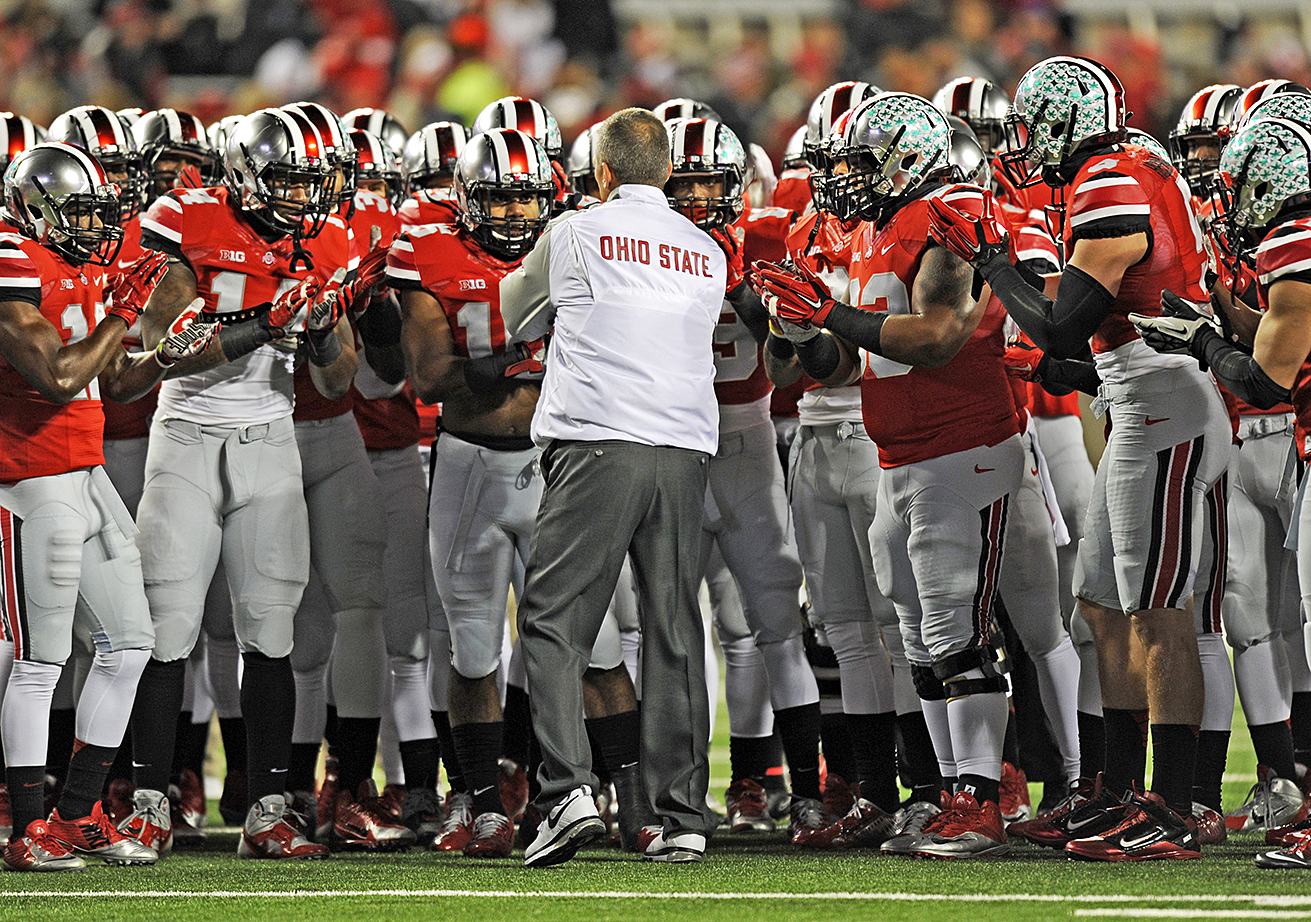 Coach Urban Meyer huddles with members of the Ohio State football team 