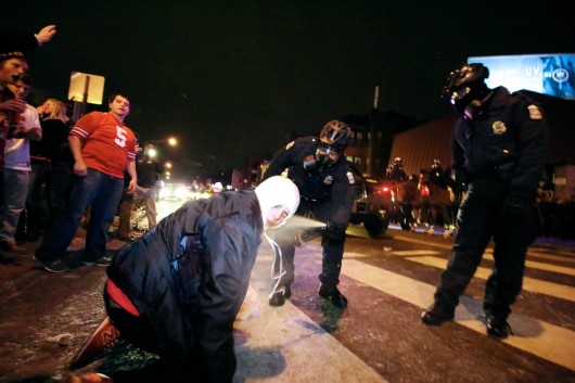 A Columbus Police officer uses pepper spray on an Ohio State fan on North High Street near OSU campus in the early morning of Jan. 13. Police responded to fan riots following OSU’s 42-20 national championship victory against Oregon on Jan. 12. Credit: Yann Schreiber / Lantern reporter
