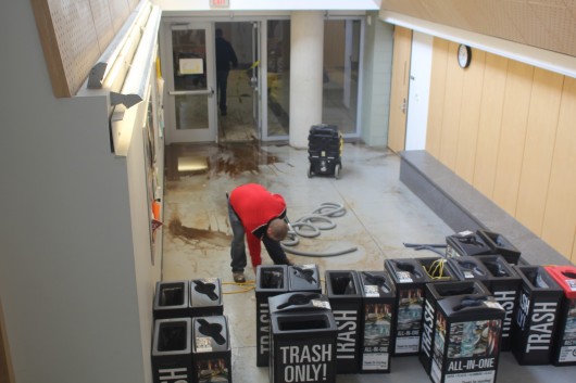 A maintenance worker cleans up some of the water damage in Scott Laboratory on Feb. 20. A fire sprinkler head froze and broke, causing flooding and water damage in the basement of the building. Credit: Robert Scarpinito / Lantern reporter
