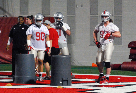 Senior defensive lineman Tommy Schutt (90) and junior defensive lineman Joey Bosa (97) wait to start the next drill during during the Buckeyes’ first spring practice on March 10 at the Woody Hayes Athletic Center.  Credit: Tim Moody / Sports editor