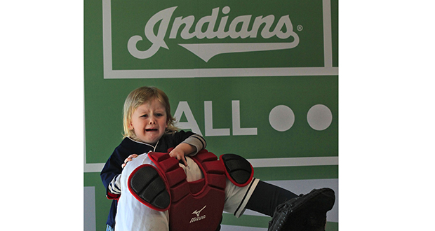 Two-year-old Finn David from Rocky River, Ohio, isn't too sure he wants to have his picture taken as a catcher inside the Kids Clubhouse area in the new Right Field District area at Progressive Field during the Cleveland Indians' home opener against the Detroit Tigers on April 10, in Cleveland. Credit: Courtesy of TNS