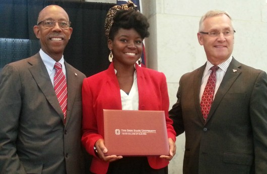 Youngstown State University President Jim Tressel (right) and University President Michael Drake (left) award Dorianeh Stanford with a certificate of completion Aug. 6 at the 2015 Ohio Export Internship Program Showcase. Credit: Michael Huson / Campus Editor