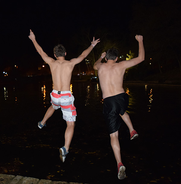Two students jump into Mirror Lake on Nov. 25 during the Mirror Lake jump. Credit: Robert Scarpinito | Copy Chief