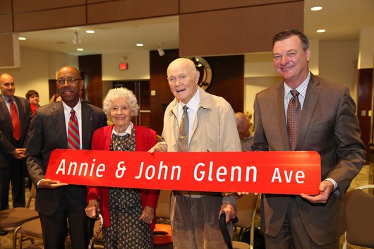 President Michael Drake, Annie Glenn, John Glenn, Board of Trustees Chair Jeffrey Wadsworth pose with the street sign for the newly named avenue on OSU campus. Credit: Courtesy of OSU