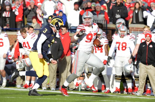 OSU junior defensive end Joey Bosa (97) runs with the football after intercepting a pass in a game against Michigan on Nov. 28 at Michigan Stadium. Credit: Lantern File Photo