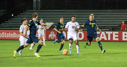 Ohio State then-sophomore Marcus McCrary (19) dribbles the ball through a group of Michigan players during a soccer game at Jesse Owens Memorial Stadium on Nov. 4, 2015. Credit: Lantern File Photo