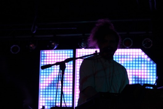 Daniel Zott silhouetted against the JR JR backdrop while playing keyboard. Credit: Mason Swires | Lantern reporter