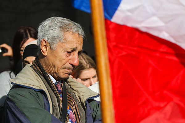 A man sheds a tear next to a tricolore French flag after a minute of silence on Nov. 16 near the Petit Cambodge restaurant in Paris,one of the first restaurants to be hit by the attacks on Friday. Credit: Yann Schreiber | For The Lantern 