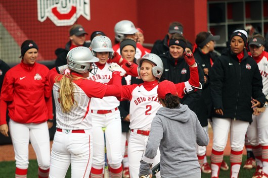 OSU junior Alex Bayne (2) is welcomed by her teammates at home plate after hitting a homerun during a game against Penn State on April 6 at Buckeye Field. Credit: Samantha Hollingshead | Photo Editor 