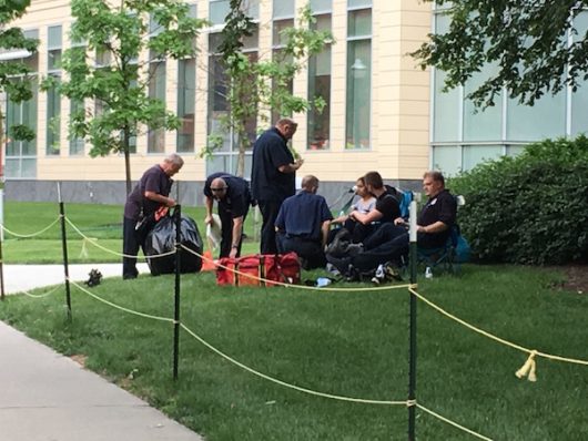 A woman sits with first responders after leaving the Chemical and Biomolecular Engineering and Chemistry building. Credit: Jacob Myers | Asst. Sports Editor