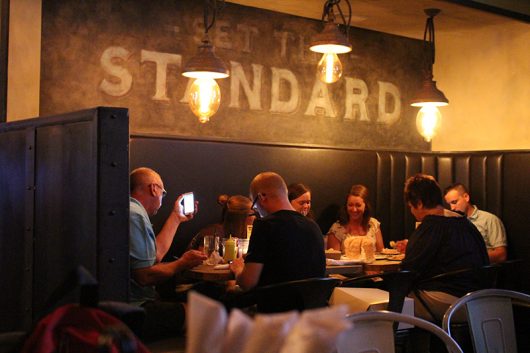 Guests dine at Standard Hall under mural that reads "Set the Standard." Credit: Kathleen Senge | Lantern Reporter