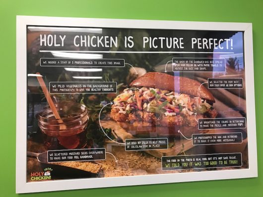 A sign depicts science behind food imagery at the Holy Chicken! pop up eatery at 2405 Shrock Rd. Credit: Elizabeth Tzagournis | Lantern Reporter