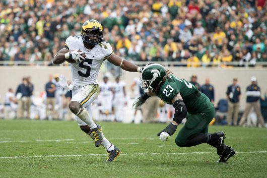 Michigan junior linebacker Jabrill Peppers (5) pushes Michigan State safety Chris Frey away during a run in Michigan's 32-23 victory in Spartan Stadium. Credit: Courtesy of U-M Photography.